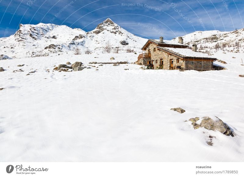 A mountain hut in a snowy mountain landscape. Val d'Aosta, Italy Vacation & Travel Tourism Adventure Winter Snow Mountain Nature Landscape Sky Clouds Rock Alps