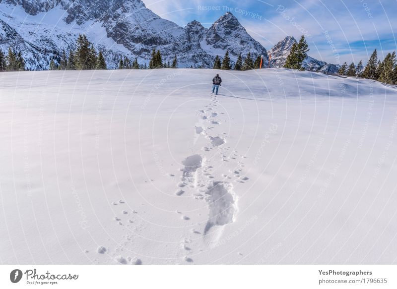 Man walking through snow on a mountain peak Tourism Winter Snow Mountain Adults 1 Human being Nature Landscape Alps Footprint Blue White Alpine attraction