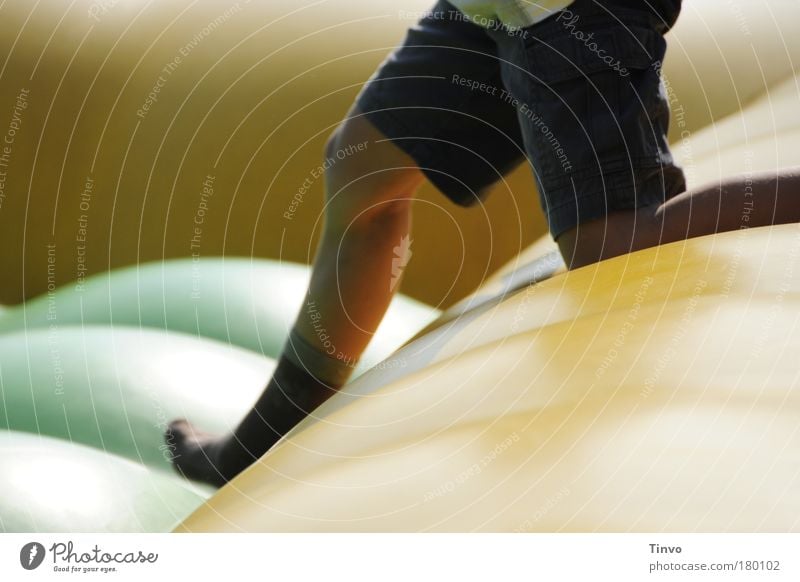 Child on bouncy castle Colour photo Exterior shot Detail Copy Space left Copy Space right Day Light Contrast Leisure and hobbies Playing Summer Boy (child) Legs