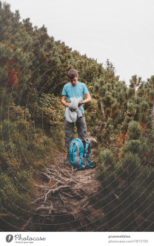 Boy packing his clothes to backpack on trail Lifestyle Vacation & Travel Adventure Freedom Summer Mountain Hiking Boy (child) 1 Human being Nature Wanderlust