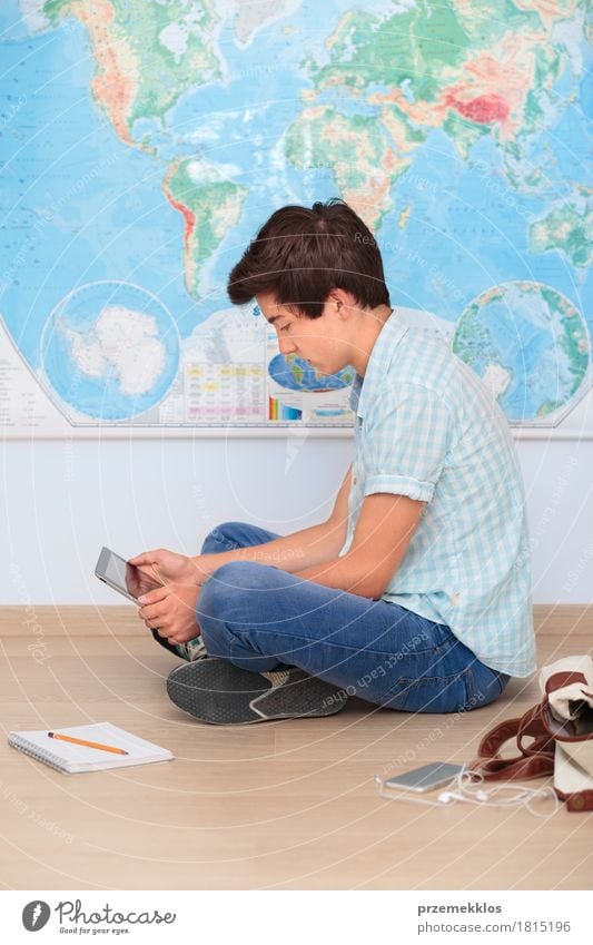 Boy sitting by the map in classroom Education School Study Classroom Schoolchild Academic studies University & College student Notebook Boy (child) 1