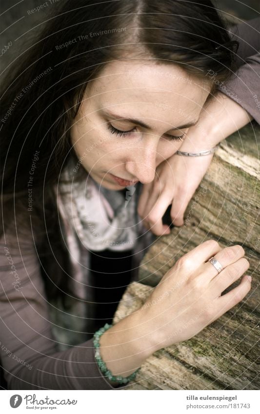 . Colour photo Subdued colour Exterior shot Neutral Background Day Portrait photograph Half-profile Downward Looking away Masculine Young woman