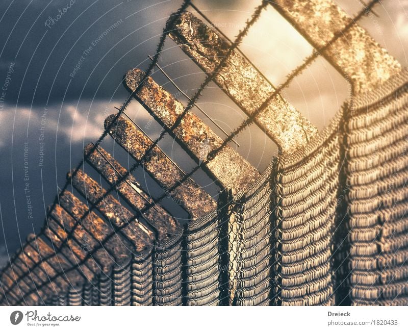 restricted area Sky Clouds Storm clouds Sun Sunlight Fence Metal Rust Threat Sharp-edged Yellow Gold Barrier Barbed wire Barbed wire fence Colour photo