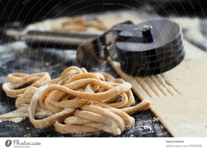 Making homemade taglatelle with a pasta rolling cutter Dough Baked goods Nutrition Italian Food Table Kitchen Tool Make Dark Fresh Tradition Ingredients manual