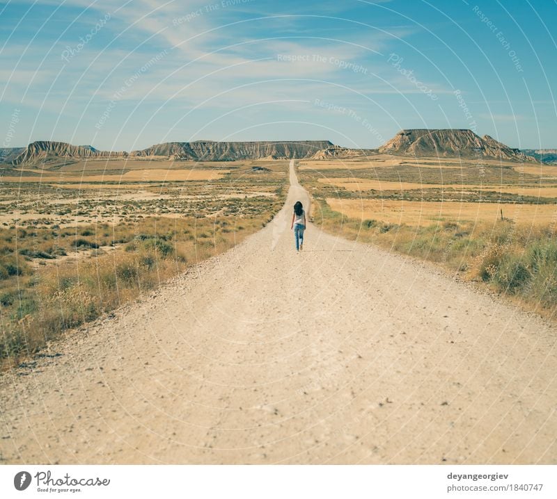 Woman walking on dirt road Relaxation Mountain Hiking Adults Nature Landscape Earth Sky Park Hill Rock Street Jeans Blue Red movie Western sierra desert Valley