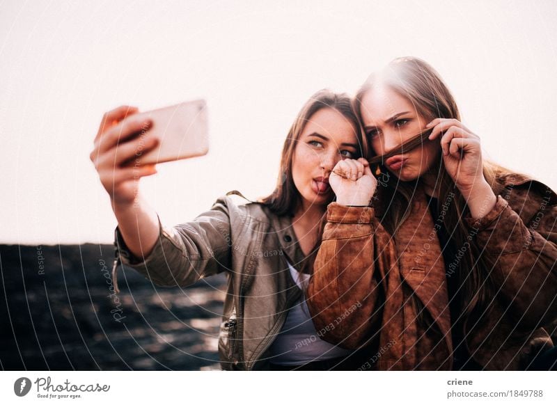 Teenage Girls taking selfies with smart phone on the beach Lifestyle Joy Happy Summer Beach Telephone Cellphone PDA Technology Entertainment electronics