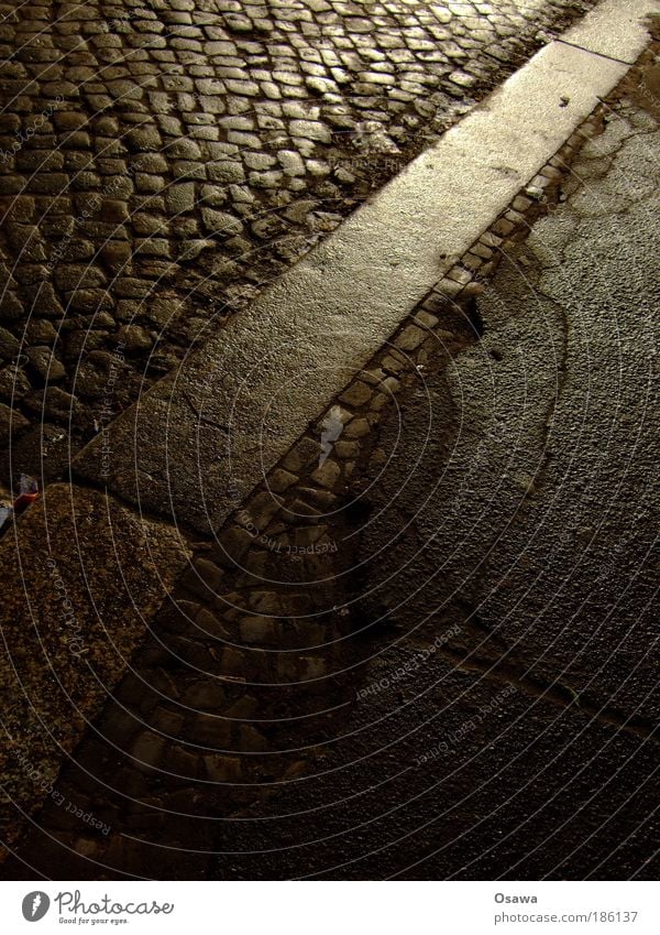 kerbstone Sidewalk Curbside Street Road traffic Town Paving stone Cobblestones Tar Asphalt Pavement Wet Damp Smoothness Glittering Reflection Think Target