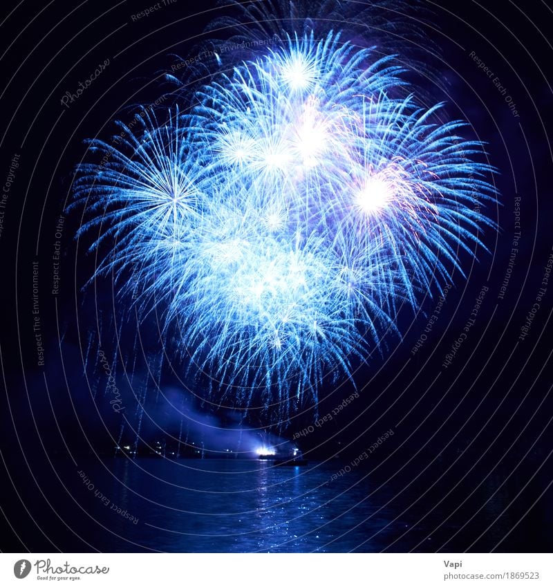 Blue fireworks on the black sky Joy Freedom Night life Entertainment Party Event Feasts & Celebrations Christmas & Advent New Year's Eve Art Water Sky Night sky