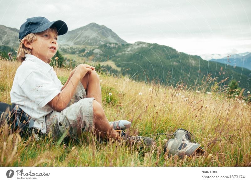 Young boy takes a rest in a meadow during a mountain hike Relaxation Vacation & Travel Tourism Adventure Summer Mountain Hiking Child Boy (child) Nature