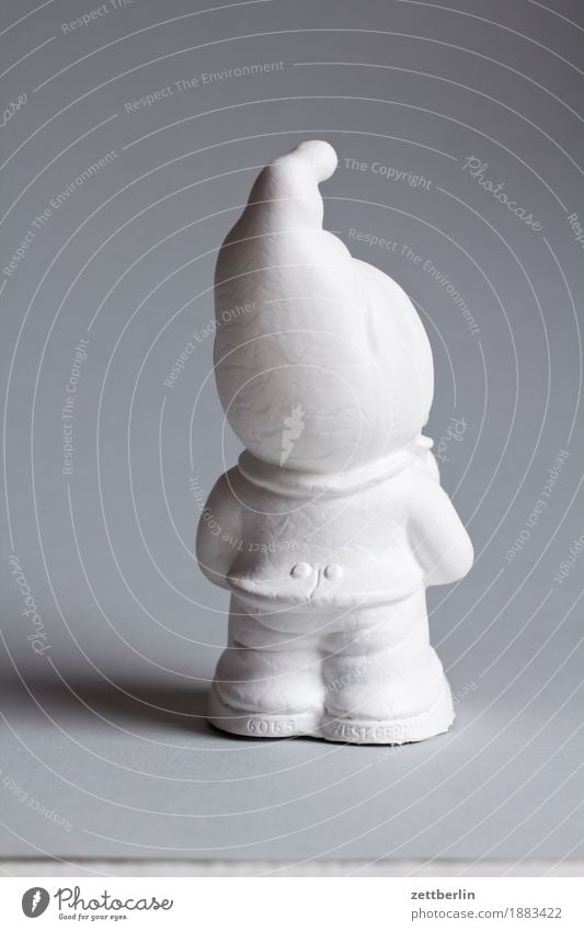 Garden gnome from behind Popular belief German Body Figure Kitsch Deserted Fairy tale Fantastic Copy Space White Point Santa Claus hat Dwarf Statue Cap