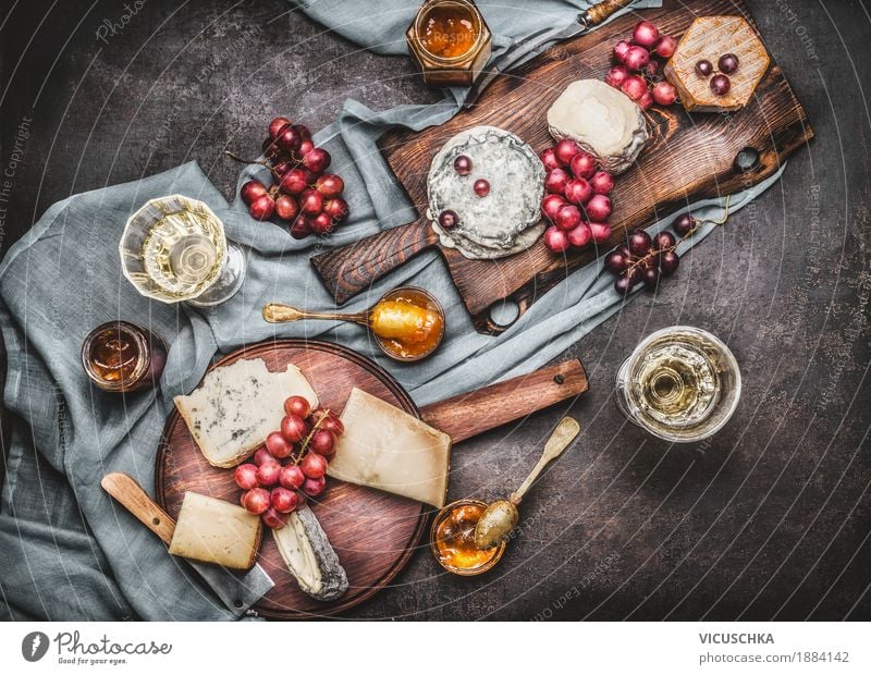 Various cheeses on cutting boards with grapes and wine Food Cheese Dairy Products Fruit Dessert Nutrition Buffet Brunch Banquet Beverage Wine Crockery Knives