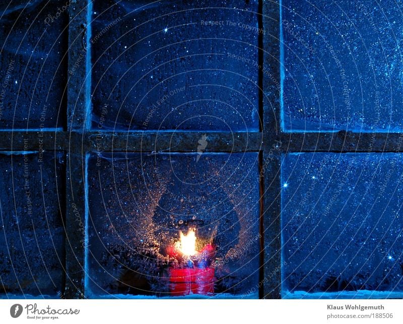 Lone candle burns and glows behind muntin window with ice flowers Winter Ice Frost Window Steel Rust Romance To console Safety (feeling of) Candlelight