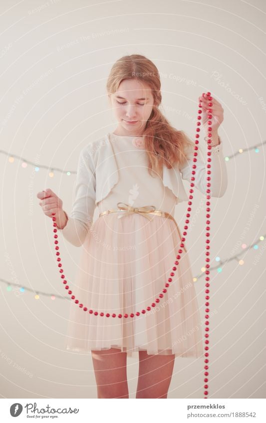 Portrait of young girl unwrapping red Christmas decorations Lifestyle Joy Happy Decoration Feasts & Celebrations Christmas & Advent Human being Girl