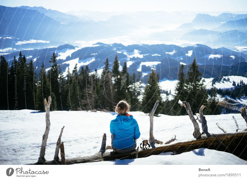 Woman sitting on a tree trunk at a pointed stone and looking into the Inn valley Relaxation Vacation & Travel Winter Adults Nature Fitness Contentment