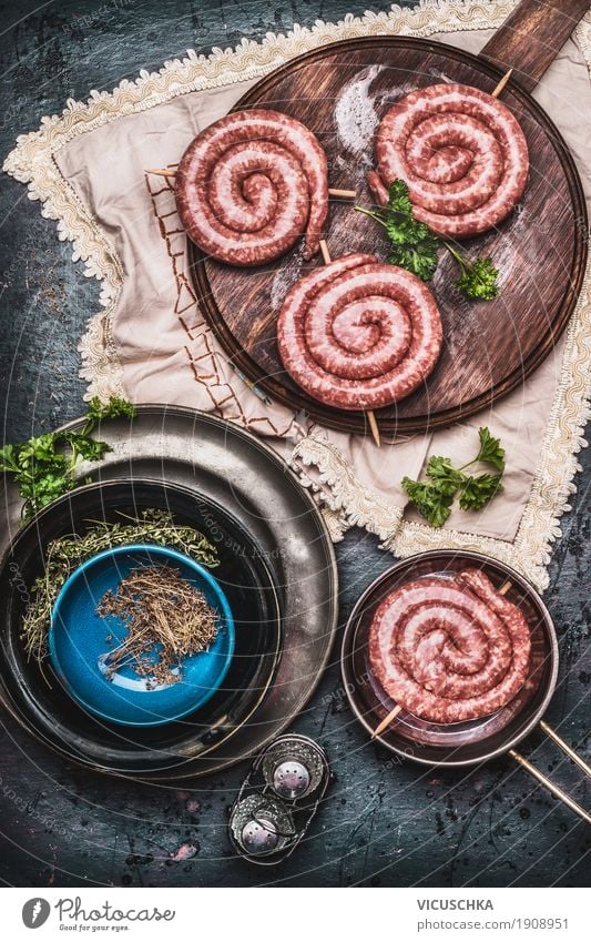 Bratwurst on vintage cutting board with herbs and spices Food Meat Sausage Herbs and spices Cooking oil Nutrition Picnic Organic produce Beverage Crockery Style