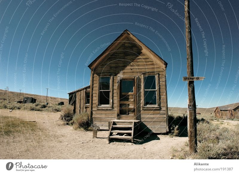 in front of the house Earth Sand Sky Drought Bushes Old Poverty Simple Bright Historic Trashy Blue Brown Gray Calm Sadness Thirst Loneliness Esthetic End Peace