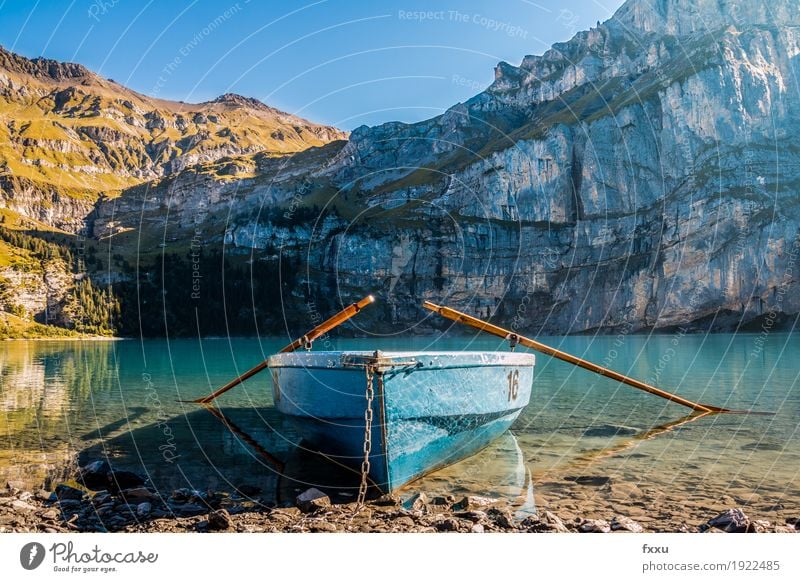 Fishing boat on Lake Oeschinen Watercraft Mountain Mountain lake Paddle Oar Rowboat Coast Lakeside Summer kandersteg Calm Deserted Loneliness Massive