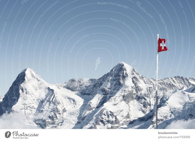 The heart of Switzerland Environment Nature Landscape Winter Beautiful weather Snow Hill Rock Alps Mountain Peak Snowcapped peak Flag Flagpole Crucifix