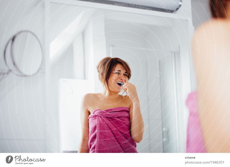 Happpy Young caucasian women brushing her teeth Lifestyle Joy Beautiful Personal hygiene Face Healthy Health care Well-being Living or residing Mirror Bathroom