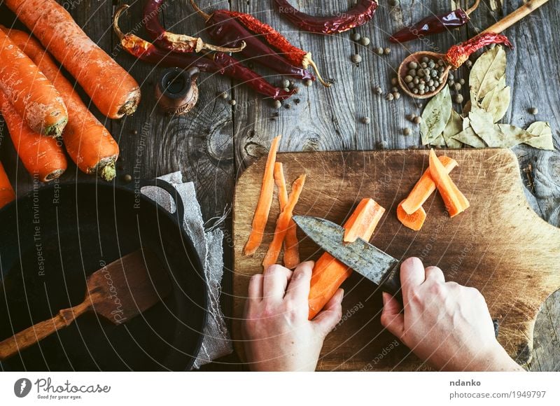 Two women's hands clean large carrots for slicing Food Vegetable Herbs and spices Nutrition Eating Vegetarian diet Crockery Pan Knives Spoon Table Young woman