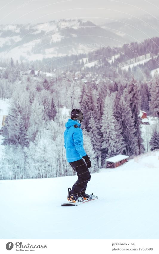 Boy riding a snowboard down the slope Lifestyle Joy Vacation & Travel Winter Snow Winter vacation Mountain Sports Snowboard Boy (child) Nature Landscape Hill