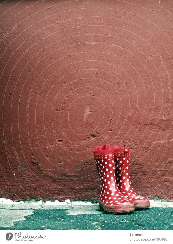 childhood memories Boots Rubber boots Joy Point Wall (building) Memory Infancy Childlike Stand Mud Experience Red Spotted Pattern Colour photo Exterior shot