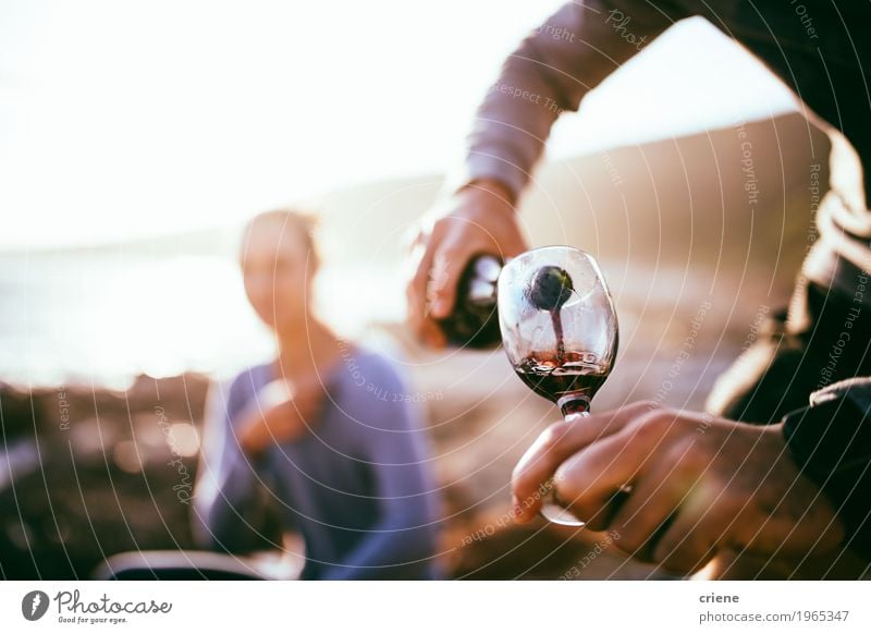 Man filling glass with wine on date at beach in sunset Picnic Beverage Alcoholic drinks Wine Bottle Glass Lifestyle Joy Happy Summer Beach Flirt Human being