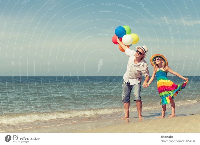 Father and daughter with balloons playing on the beach Lifestyle Joy Relaxation Leisure and hobbies Playing Vacation & Travel Trip Freedom Summer Sun Beach