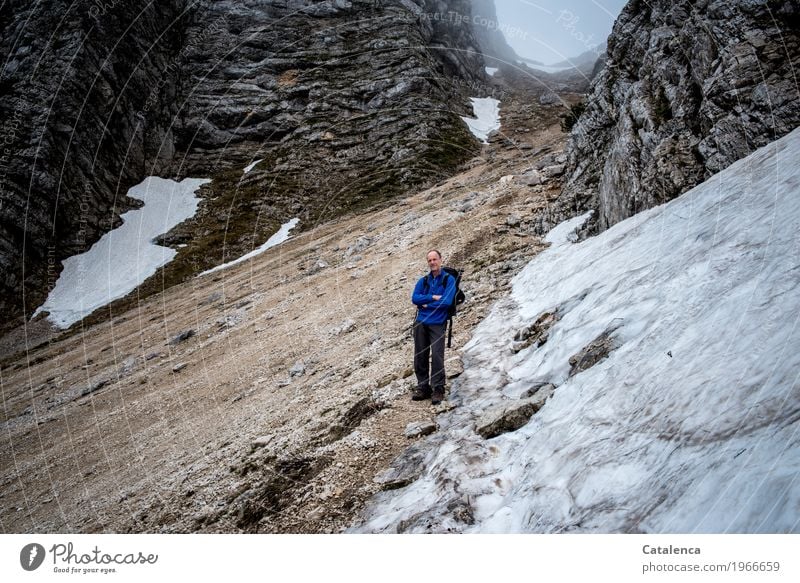 Hiker in mountain on snow field Winter Mountain Hiking Masculine Man Adults 1 Human being Landscape Spring Bad weather Fog Rock Alps Glacier Observe Fitness