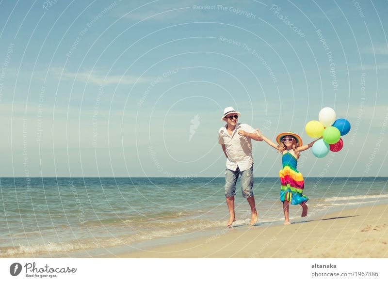 Father and daughter with balloons playing on the beach Lifestyle Joy Relaxation Leisure and hobbies Playing Vacation & Travel Trip Freedom Summer Sun Beach