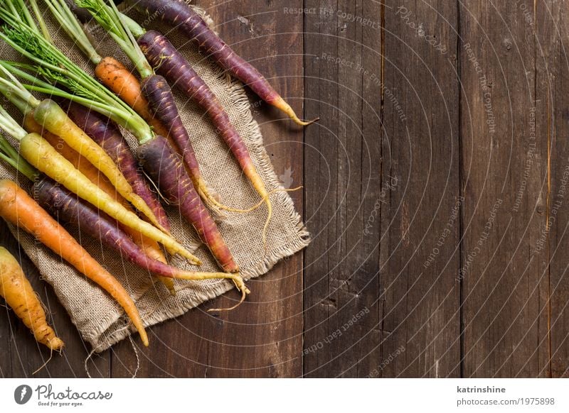 Fresh organic rainbow carrots on a wooden table Vegetable Nutrition Vegetarian diet Brown Yellow Carrot Farmer food Harvest healthy market orange Organic Raw