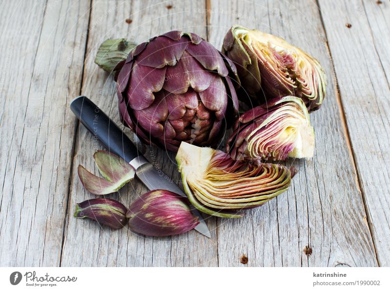 Roman Artichokes on a wooden board with knife Vegetable Nutrition Vegetarian diet Knives Fresh Gray Green agriculture Purple cooking Cut Edible food Half