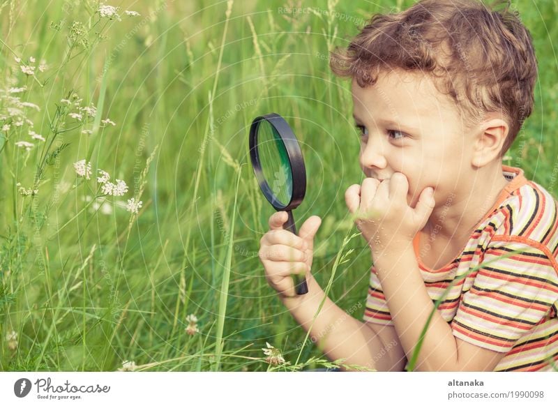 Happy little boy exploring nature with magnifying glass at the day time Lifestyle Joy Face Playing Summer Garden Science & Research Child School Human being