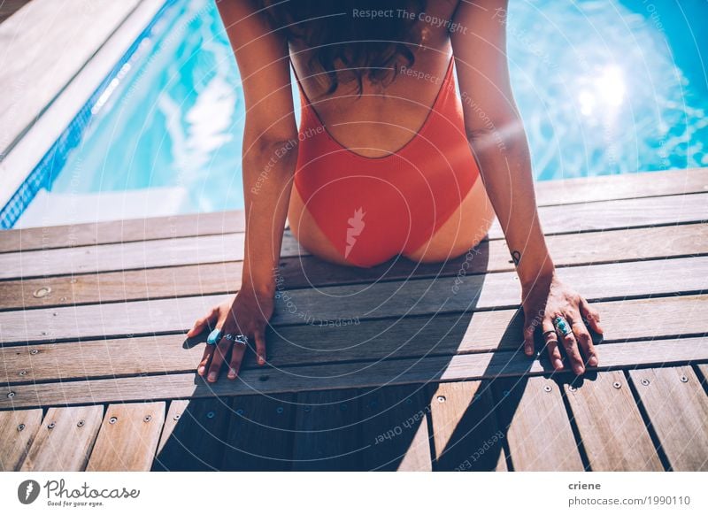 Back view of woman sitting at swimming pool in swimwear Lifestyle Joy Relaxation Spa Swimming pool Vacation & Travel Summer Feminine Young woman