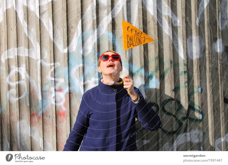 Woman in a coat with glasses and pennant in front of a graffiti wall made of concrete Lifestyle Feasts & Celebrations Birthday Feminine Young woman