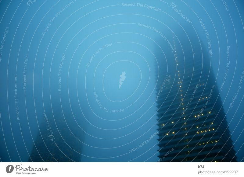 towers in fog Sky Fog Town Skyline High-rise Manmade structures Building Architecture Window Threat Dark Large Tall Above Under Blue Fear Cold Colour photo