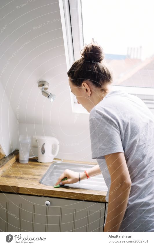 Young woman do the cleaning in modern minimal kitchen. Lifestyle Flat (apartment) House (Residential Structure) Interior design Kitchen Human being Woman Adults