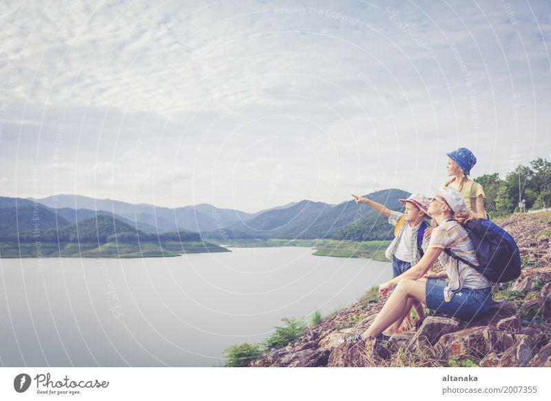 Happy family standing near the lake at the day time. Lifestyle Joy Leisure and hobbies Vacation & Travel Trip Adventure Freedom Camping Summer Mountain Hiking