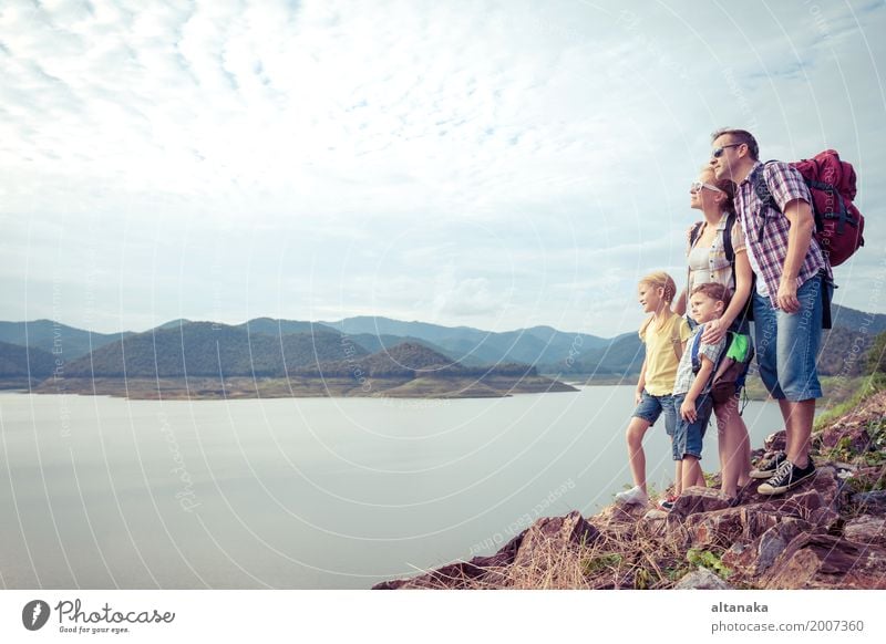 Happy family standing near the lake at the day time. Lifestyle Joy Leisure and hobbies Vacation & Travel Trip Adventure Freedom Camping Summer Mountain Hiking