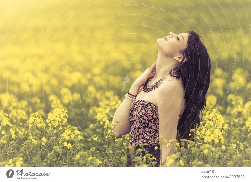 Attractive pretty girl relaxes and enjoys her youth and warm summer sun. Eyes are closed and head is stretched upwards to the sky. Nutrition Lifestyle Joy Happy