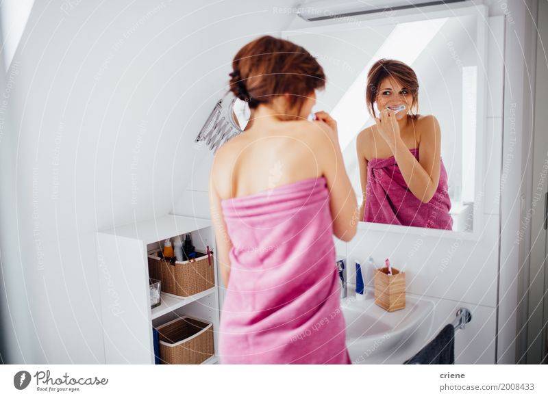 Young happy woman brushing her teeth in bathroom Lifestyle Happy Personal hygiene Body Healthy Health care Mirror Bathroom Feminine Young woman