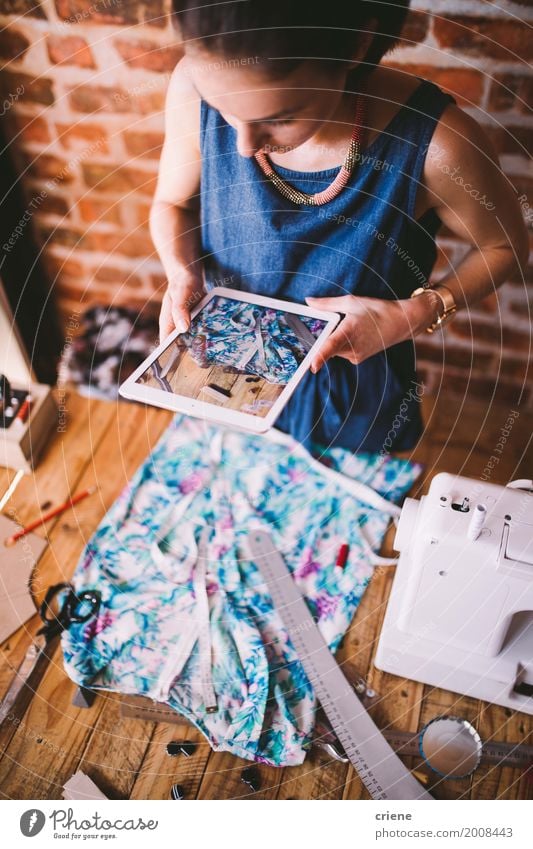 Young female blogger taking photo of dress with tablet Design Work and employment Profession Office Craft (trade) Business Screen Camera Sewing machine