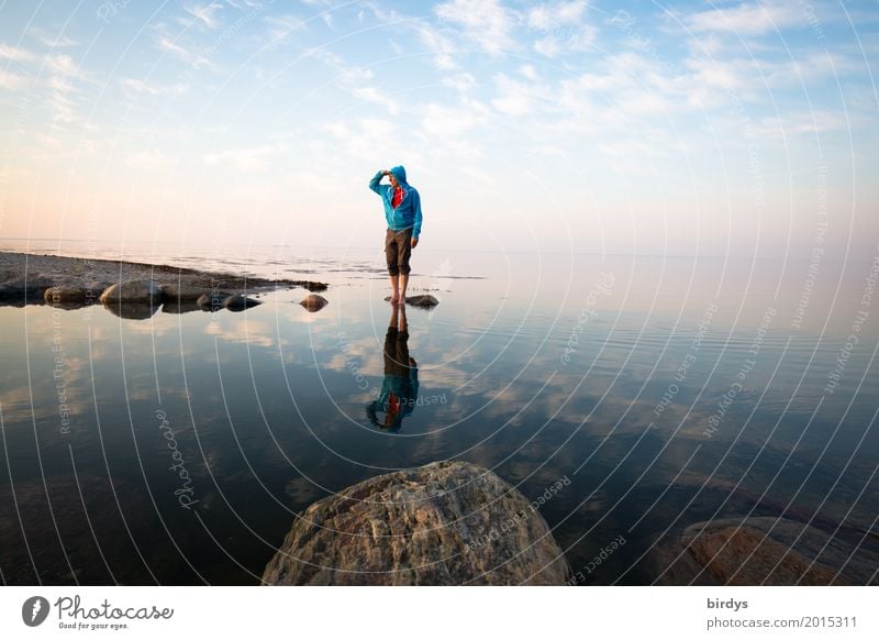 Man with turquoise hoody stands on a rock in the sea and looks into the distance Contentment Calm Masculine Adults 1 Human being 45 - 60 years Water Sky Horizon