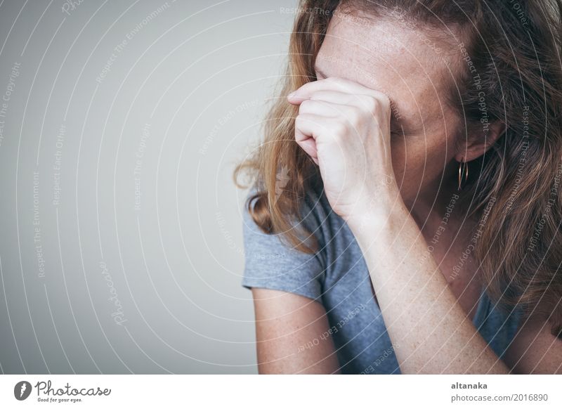 one sad woman sitting near a wall and holding her head in her hands Lifestyle Face Human being Girl Woman Adults Family & Relations Sadness Cry Emotions Concern