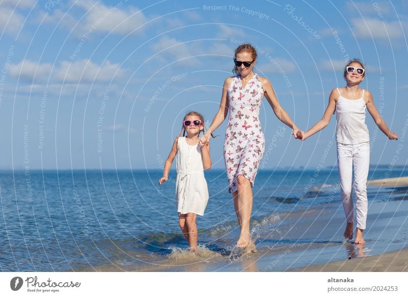 Mother and children playing on the beach at the day time. Concept of friendly family. Lifestyle Joy Relaxation Leisure and hobbies Playing Vacation & Travel