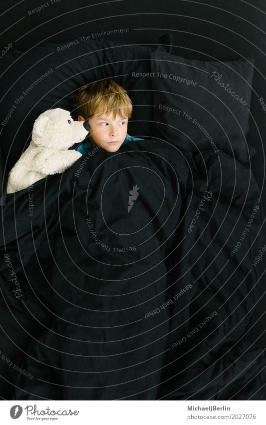 Schoolchild in bed with soft toy looking anxiously to the side Bed Human being Masculine Child Boy (child) Infancy 1 3 - 8 years Teddy bear Cuddly toy Lie