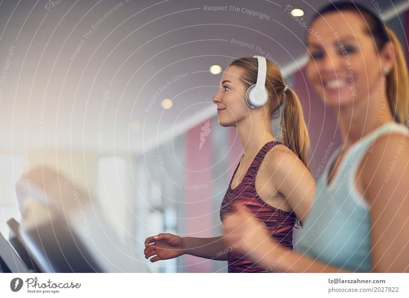 Attractive Woman with headphones on treadmill in the gym Lifestyle Happy Beautiful Face Leisure and hobbies Sports Adults 2 Human being 18 - 30 years