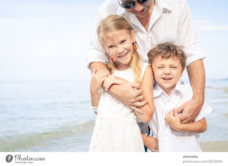 Father and children playing on the beach at the day time. Concept of friendly family. Lifestyle Joy Relaxation Leisure and hobbies Playing Vacation & Travel