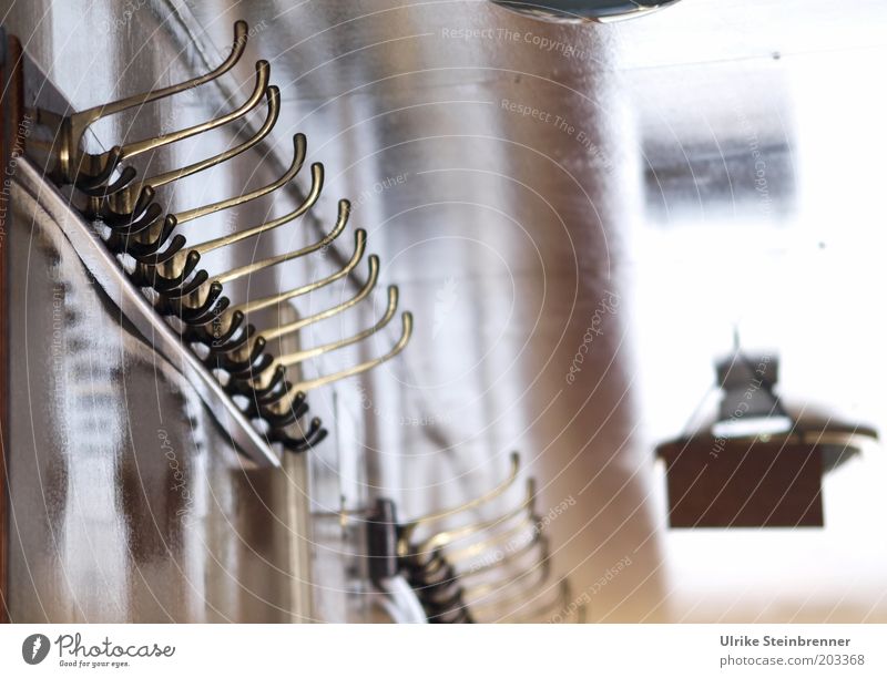 Row of old fashioned coat hooks on a ship Checkmark Hang up Lamp Ceiling light Light blurriness Wall (building) Glittering Interior design Curved Warped Empty