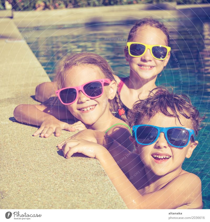 Three happy children playing on the swimming pool Lifestyle Joy Happy Face Relaxation Swimming pool Leisure and hobbies Playing Vacation & Travel Summer Sun